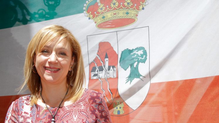 La alcaldesa de Güevéjar, María del Carmen Araque, con la bandera de fondo. Foto: Álex Cámara