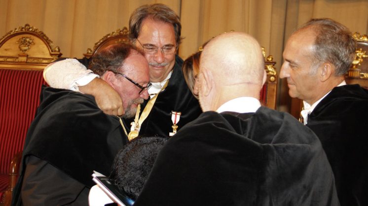 Lodeiro (izquierda) recibe el abrazo de uno de los rectores andaluces presente en el acto. Foto: Álex Cámara 