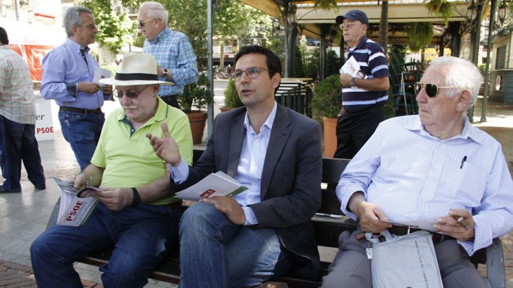 Cuenca explica a algunos de los mayores en la Plaza del Campillo sus principales propuestas sobre economía. Foto: Álex Cámara