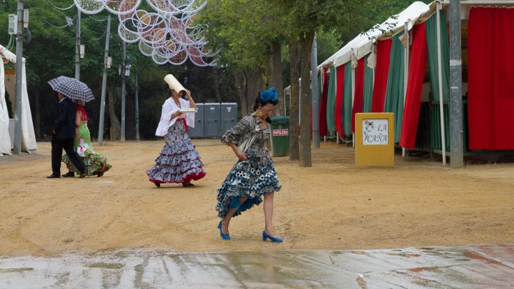 Dos mujeres intentan resguardarse de la lluvia que caía en el recinto ferial. Foto: Antonio Ropero