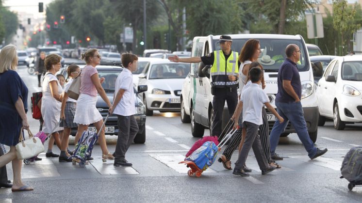 Un agente regula el paso de escolares en la calle Arabial de la capital. Foto: Álex Cámara